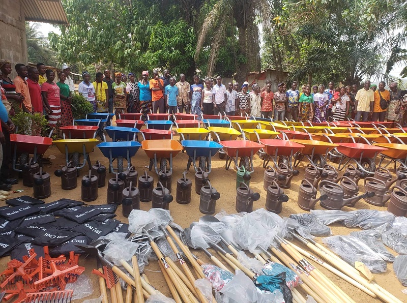 program participants stand with wheelbarrows and shovels