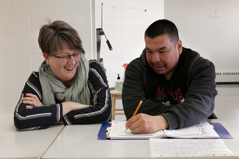 Heather sits with Frank learning to write