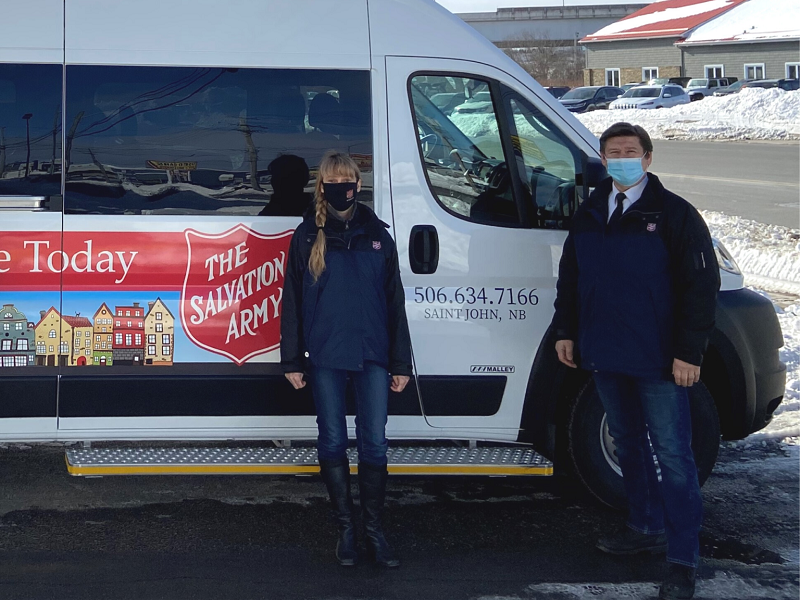 Salvation Army workers stand in front of mobile feeding van