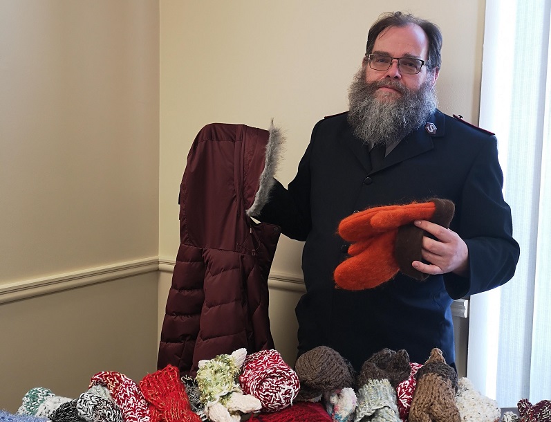 Salvation Army pastor stands with donate clothes such as coats and mitts