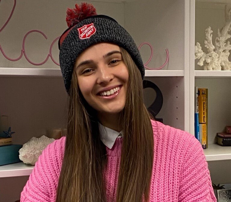 Anastasiia wears pink sweater with Salvation Army branded toque