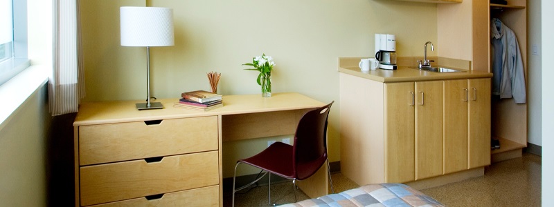 Emergency shelter room with bed, desk, sink and closet