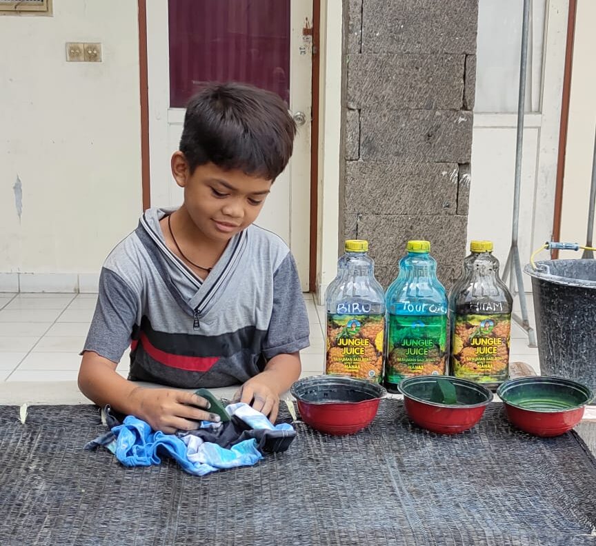 a boy smiling and playing with a cloth