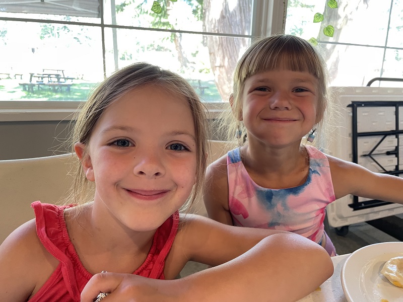 Two female youth smile while at March break camp