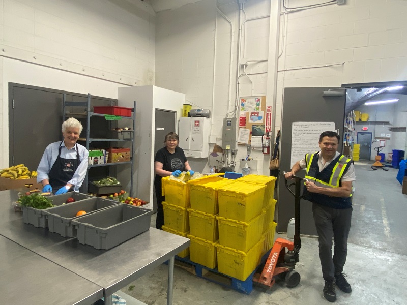 Food bank workers and volunteers prepare bins of food