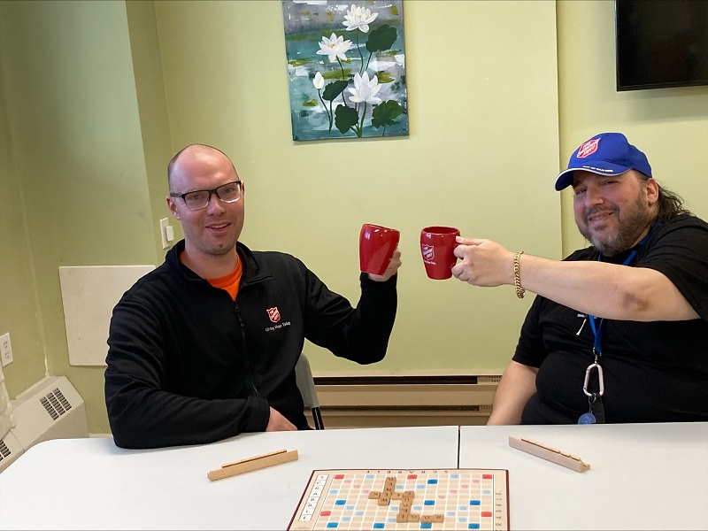 Bob and his counsellor Jonathan play board game and raise mugs in praise