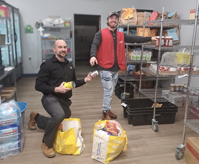 Volunteers stock empty shelves at food bank