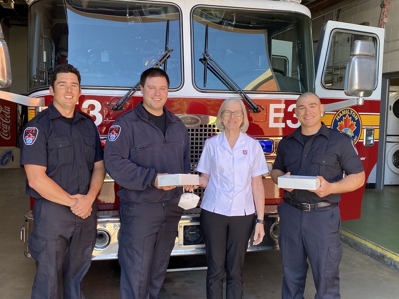 Firefighters in Hamilton Ont., accept doughnuts while standing in front of truck