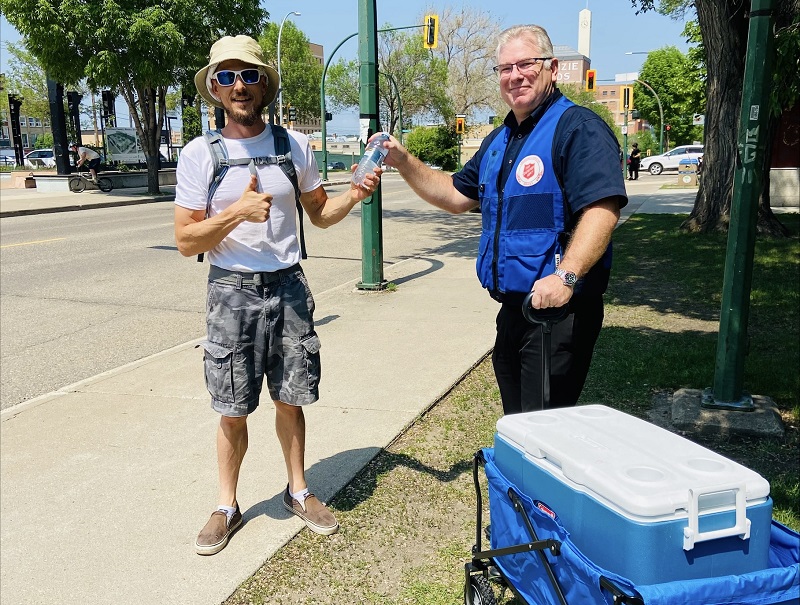 Major Jamie Rands delivers water bottle to man downtown