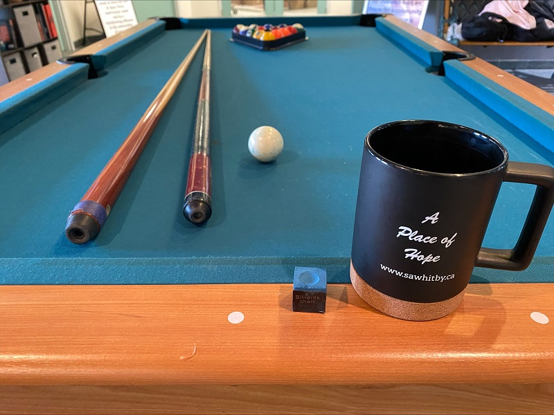Pool table with mug that says "A Place of Hope"