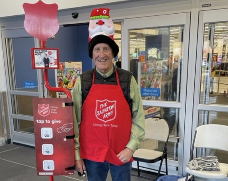 kettle volunteer stands beside kettle with tip tap options