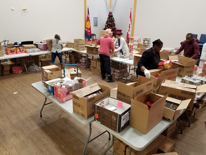 Volunteers sort boxes of Christmas help