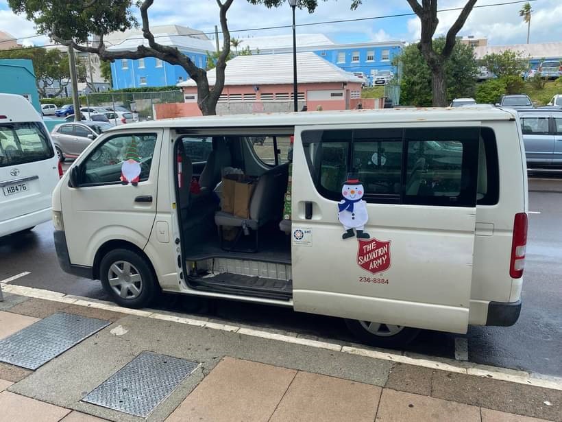 Salvation Army branded white van with doors open to accept donations
