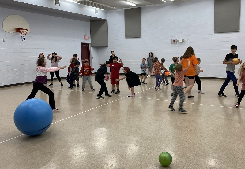 children in gym playing balloon game