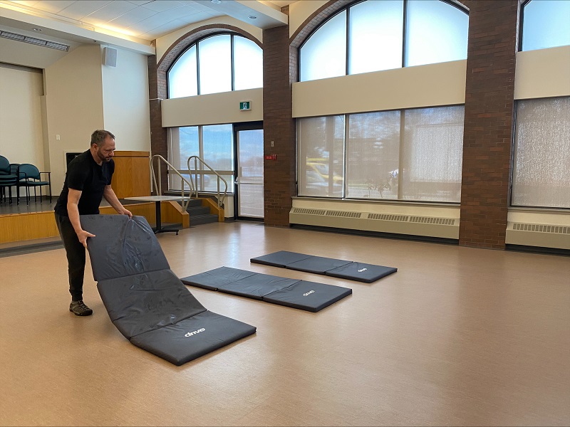 Salvation Army worker lays mats for extreme weather response