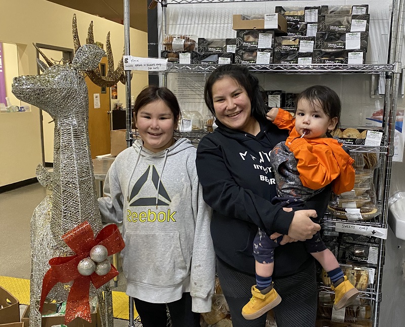 Kristen and family stand in front of food shelf