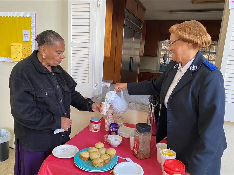 Salvation Army pastor serves cup of coffee to client