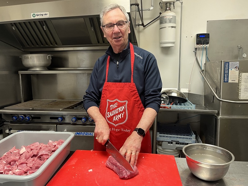 volunteer prepares meat for meal program