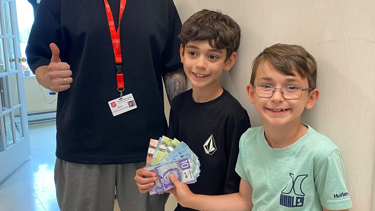 Chase and Rylan hand cash to Salvation Army worker