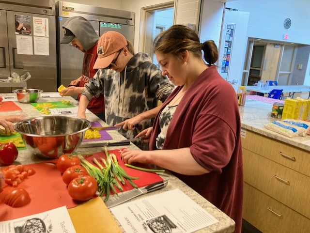 3 people preparing food in a kitchen